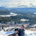 Ali sitting with Guinness Hiking in the mountains